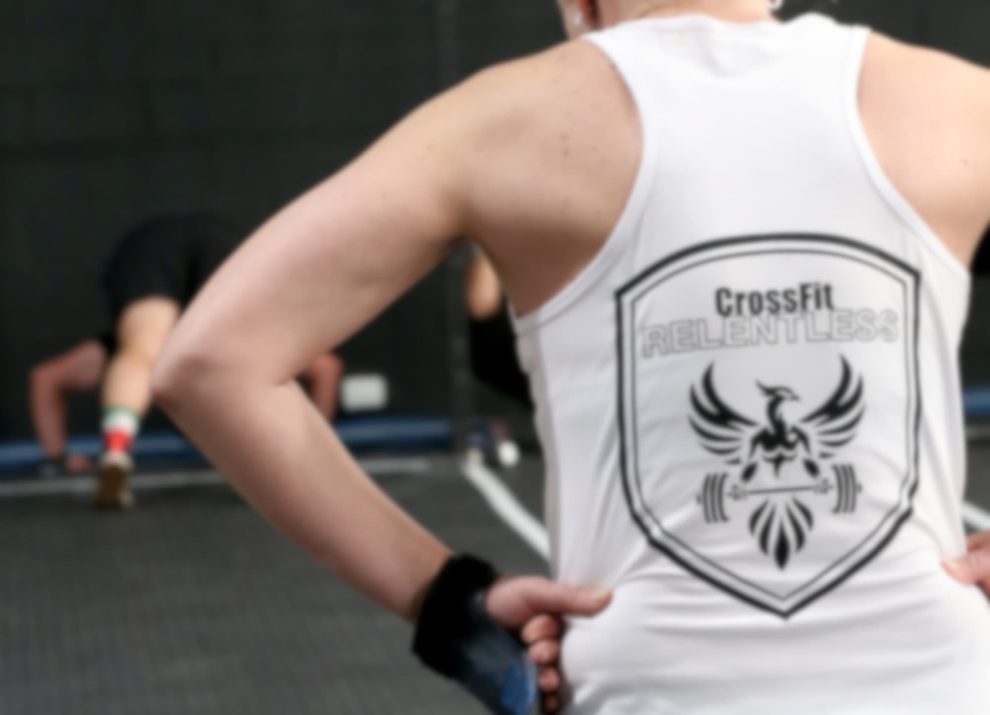 Coach in a Relentless CrossFit vest watching an athlete train